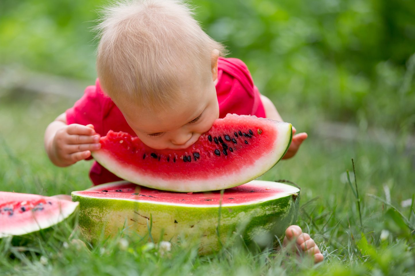 Baby eating watermelon outdoors