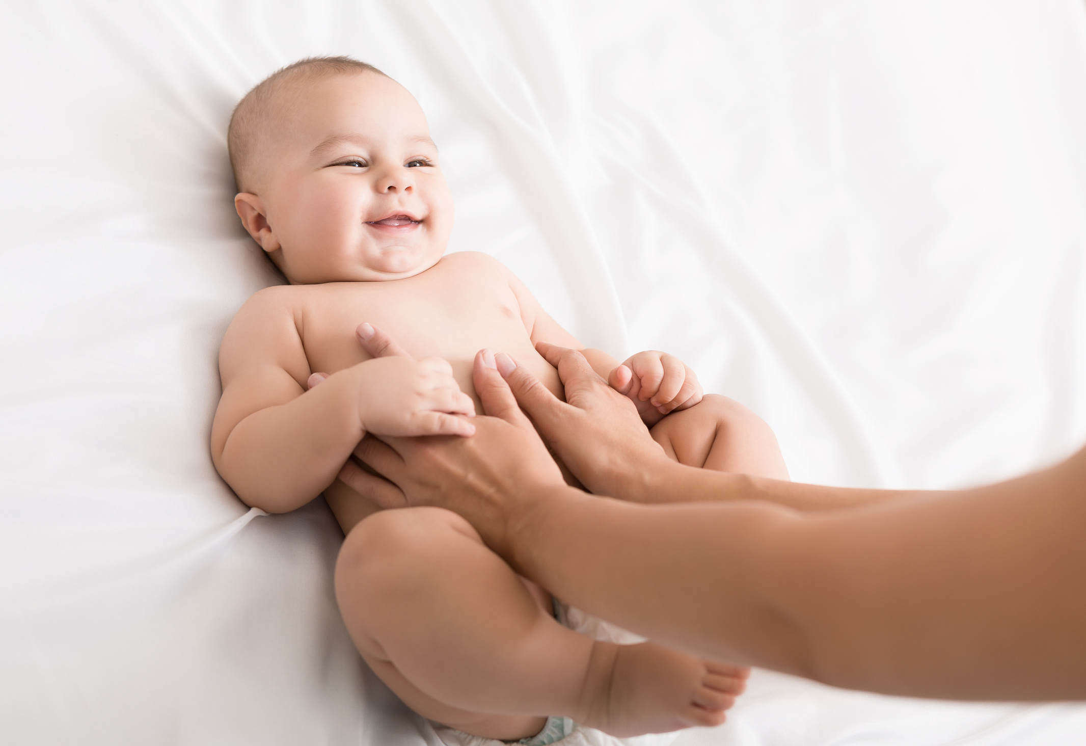 Masseur massaging tummy of baby during colic